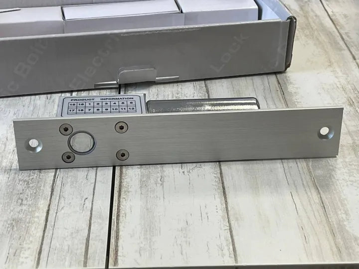 Close-up of the Electric Bolt Lock mechanism on a wooden background, showing the bolt and mounting holes.

