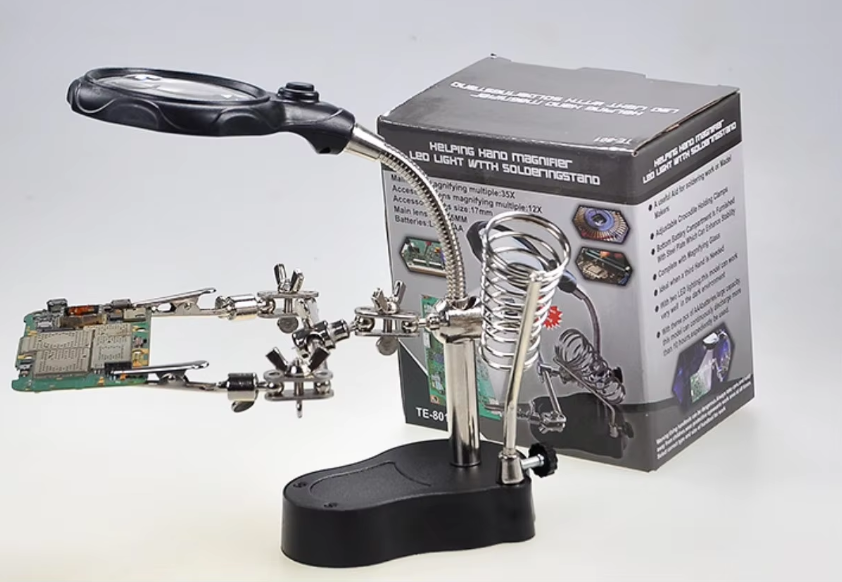 Soldering station with magnifying glass and PCB board next to its packaging on a white background